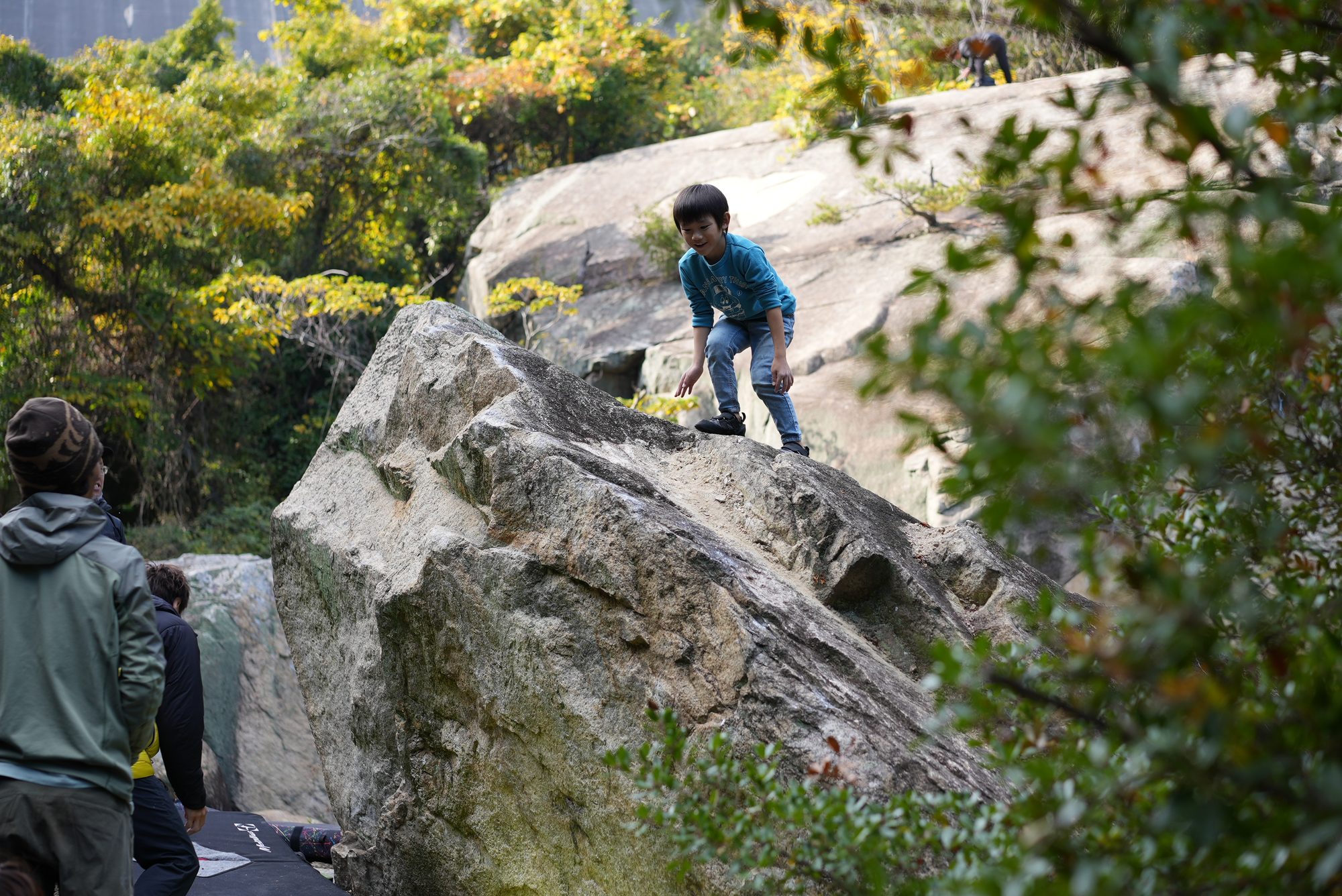 吉田の岩場の大きな岩の上に立つ子ども